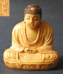 small Japanese ivory Buddha with  deep golden patina and fine graining (1.75 in. tall)  - 19th C  signed by the artist